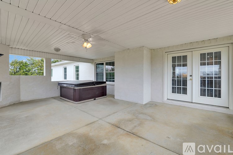 A spacious room with a hot tub and sliding glass doors.
