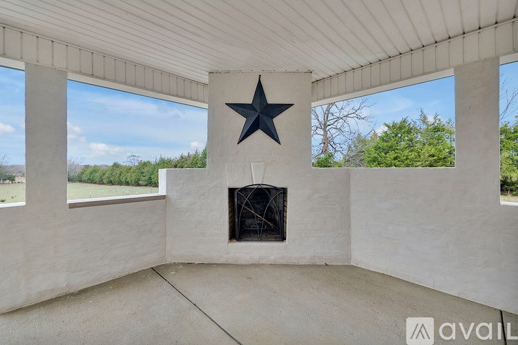 A large star is mounted on a wall above a fireplace in a room with a white ceiling and walls.