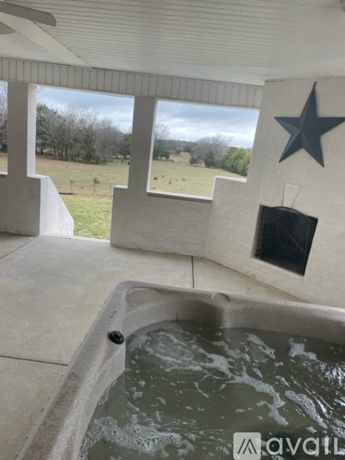 A hot tub sits in the middle of a room with a star on the wall.