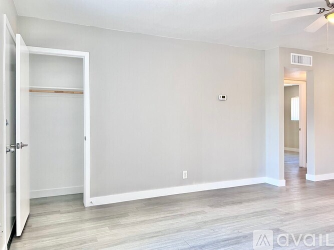 A room with a white door and a fan on the ceiling.