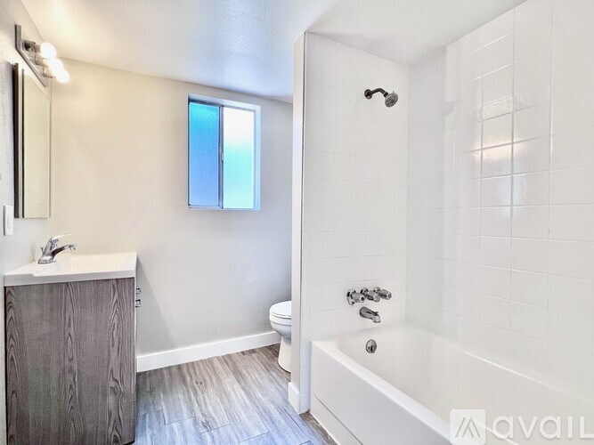 A bathroom with a tub, toilet, and sink.