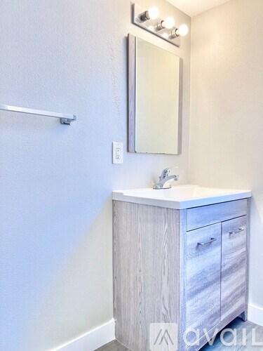 A bathroom vanity with a mirror and lights above it.