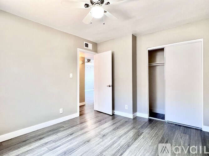 A room with a ceiling fan and two doors.