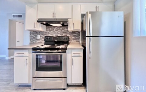 A modern kitchen with a stainless steel refrigerator and oven.
