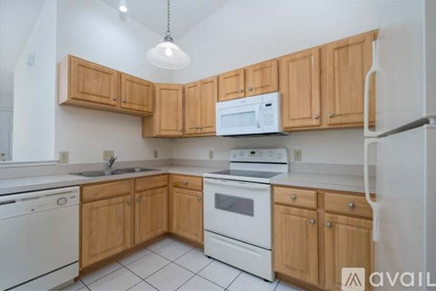A kitchen with wooden cabinets and white appliances.