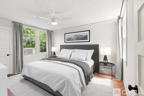 A bedroom with a large bed and a ceiling fan.