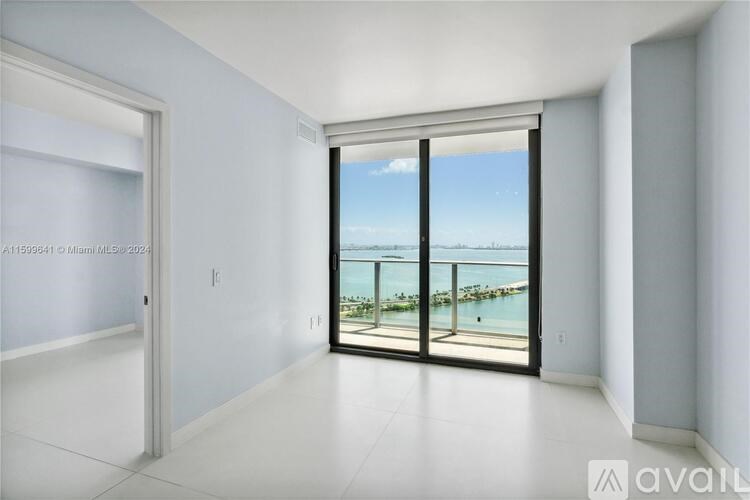 A room with a view of a body of water through large windows.