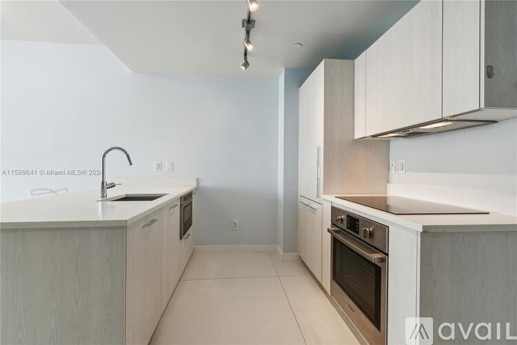 A kitchen with white cabinets and a stainless steel oven.