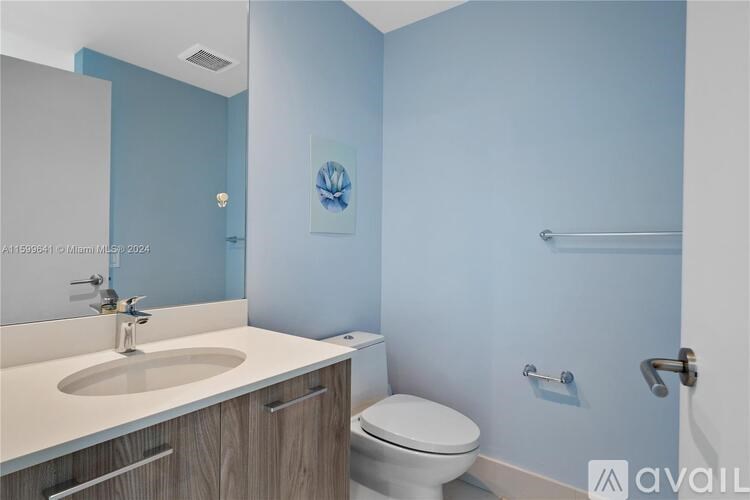 A bathroom with blue walls and a white toilet.