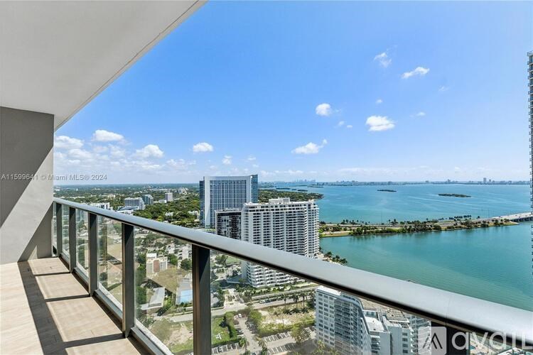 A balcony overlooks a cityscape with a body of water and buildings.