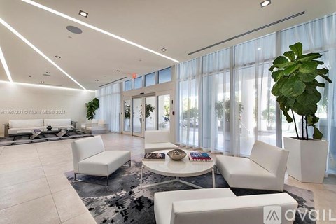 A modern living room with white furniture and a large window.