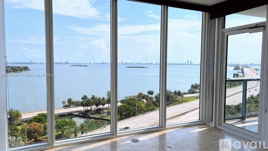 A room with a view of a bridge and water.