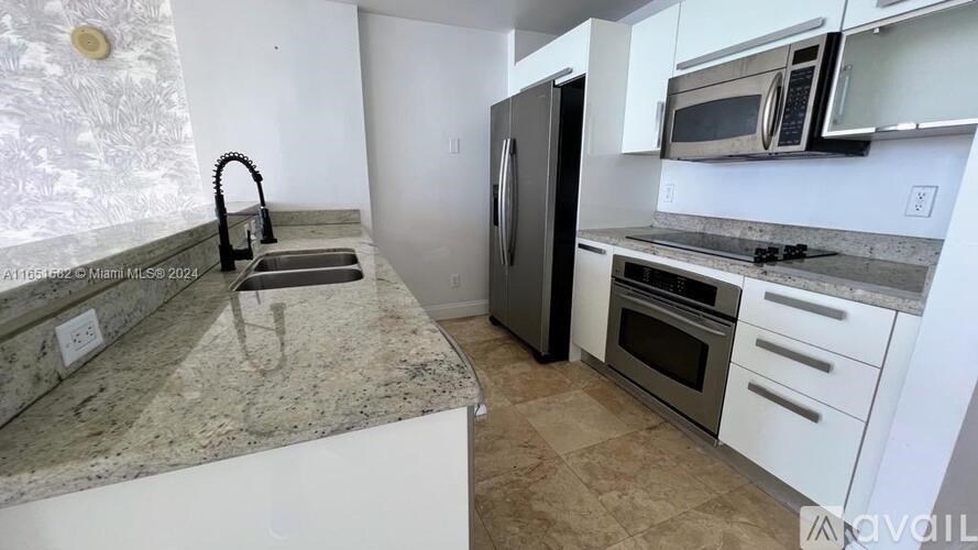 A kitchen with granite countertops and stainless steel appliances.