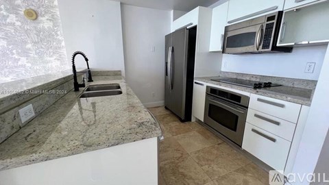 A kitchen with granite countertops and stainless steel appliances.