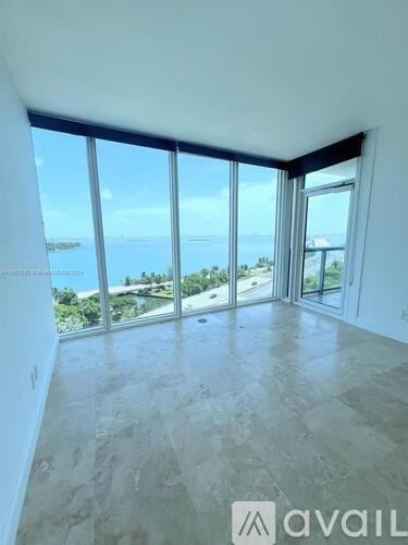 A room with large windows overlooking a body of water.