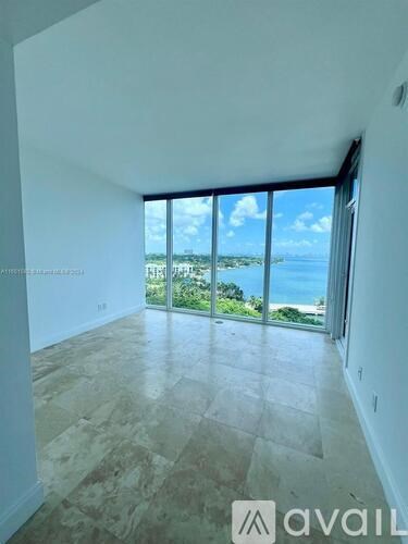 A room with a view of the ocean through large windows.