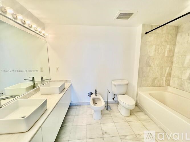 A bathroom with a white toilet, sink, and bathtub.
