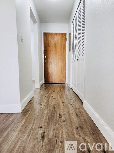 A hallway with a wooden door and white walls.