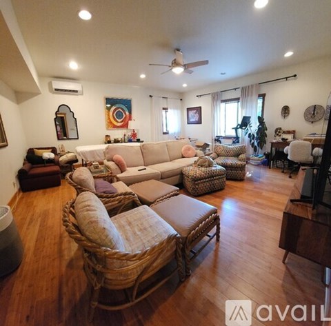 A living room with a sofa set and a wicker chair.