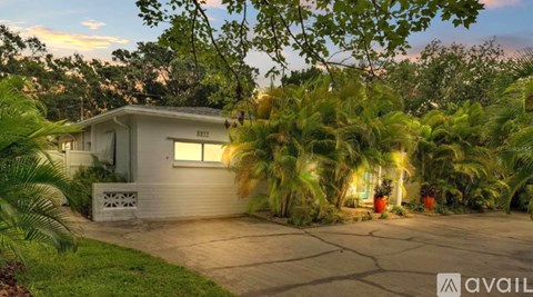 A house with a driveway and trees around it.
