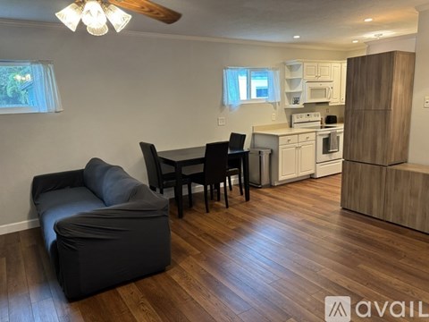 A kitchen with a black chair and a black sofa.