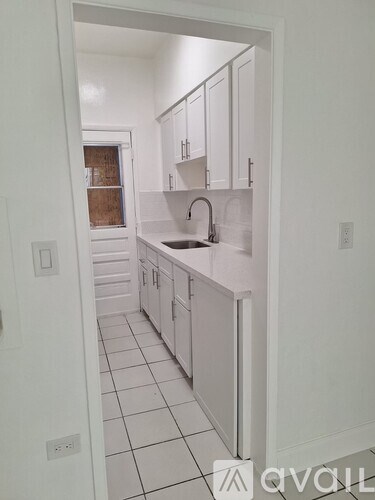 A white kitchen with a sink and cabinets.