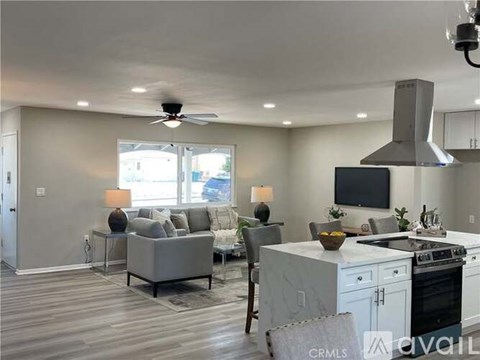 A modern kitchen with a grey sofa and a white countertop.