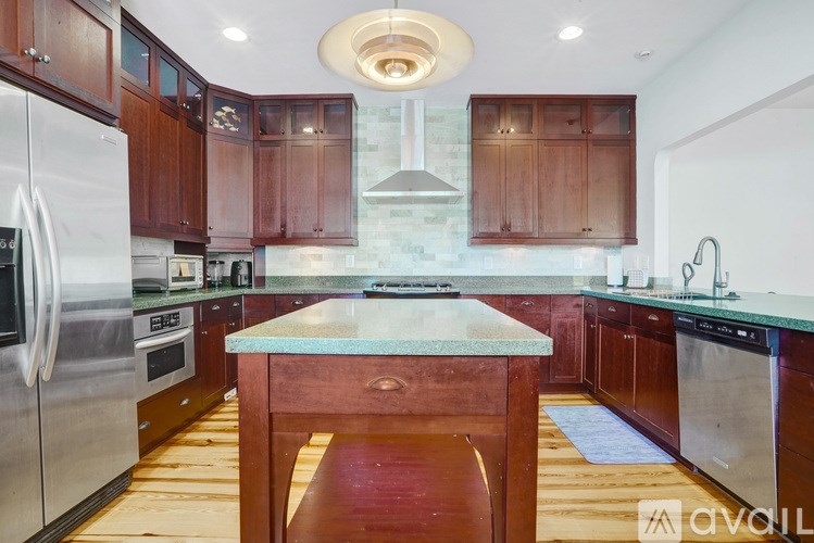 A kitchen with wooden cabinets and a marble countertop.