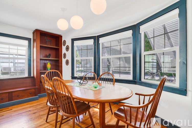 A dining room with a wooden table and chairs.