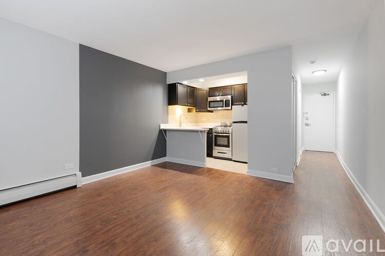 A spacious kitchen with wood flooring and a modern design.