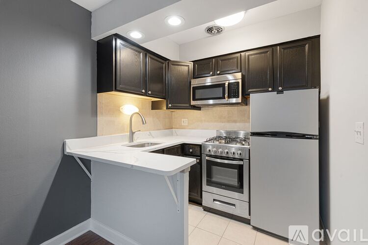 A kitchen with black cabinets and stainless steel appliances.