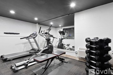 A home gym with a treadmill, exercise bike, and weights.