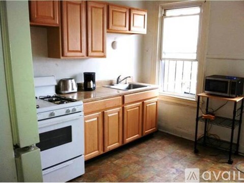 A kitchen with wooden cabinets and a white stove top oven.