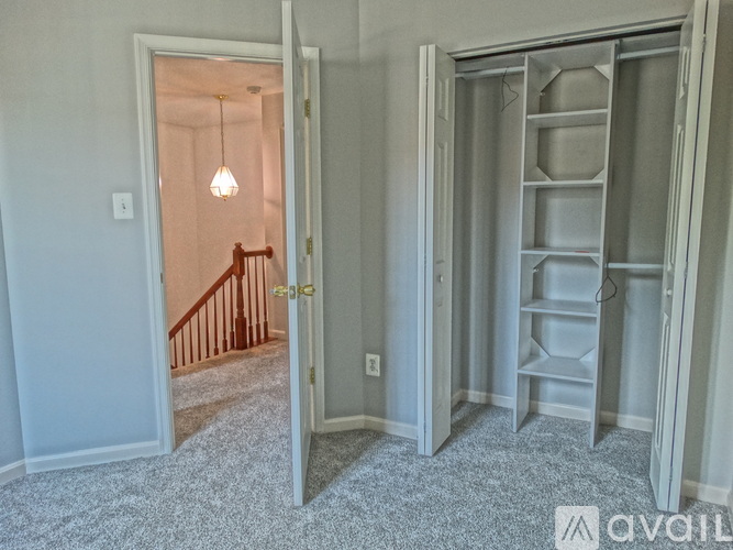 A room with a white door and a grey shelving unit.