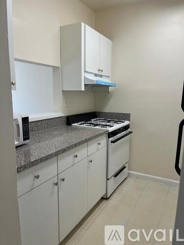 A kitchen with white cabinets and a granite countertop.