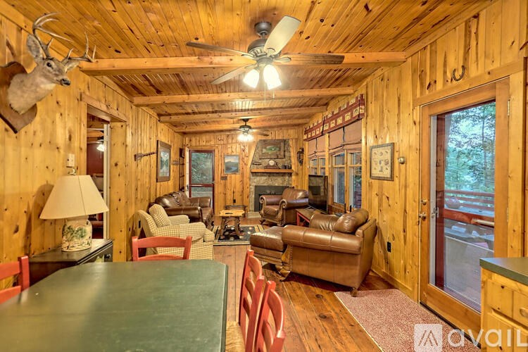 A living room with wood paneling and a deer head mounted on the wall.