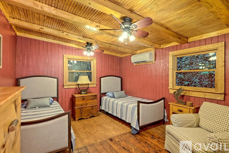 A bedroom with a bed, a chair, and a ceiling fan.