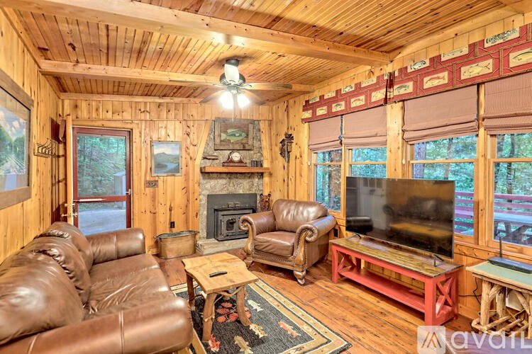 A living room with wooden walls and a fireplace.