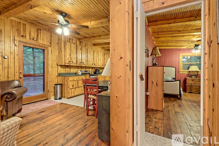 A wooden room with a ceiling fan and a chair.