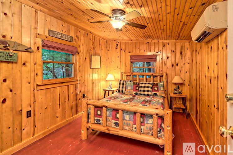 A wooden room with a bed and a window.