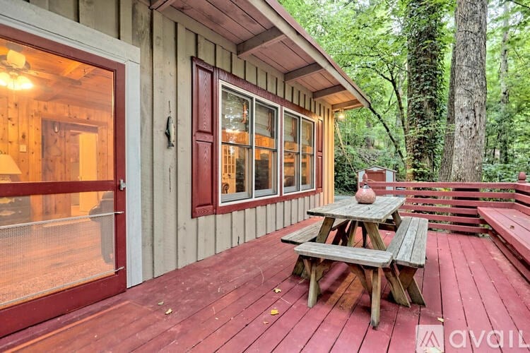 A wooden deck with a picnic table and benches.