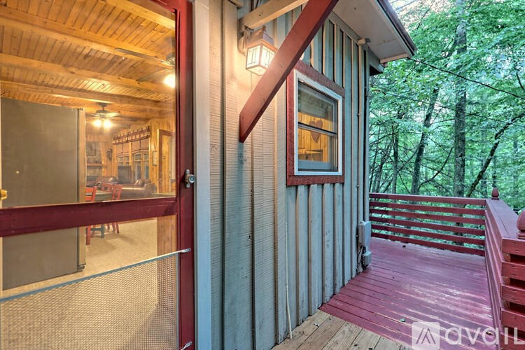A wooden deck with a red railing and a glass door leading to a dining area.