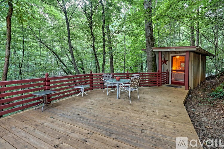 A wooden deck with a table and chairs overlooking a forest.