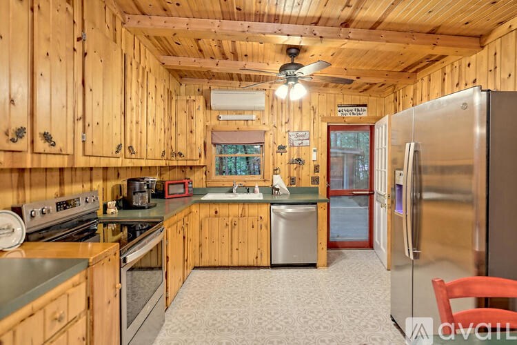 A kitchen with wooden cabinets and a stainless steel refrigerator.