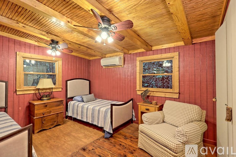 A room with a bed, chair, and a ceiling fan.