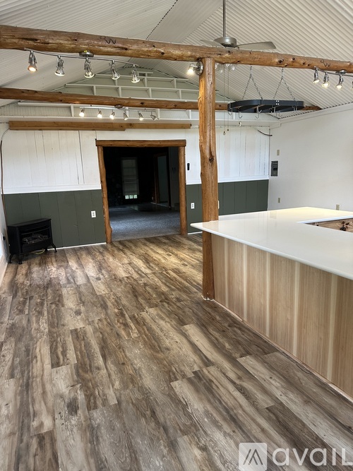 A room with a carpeted floor and a ceiling fan.