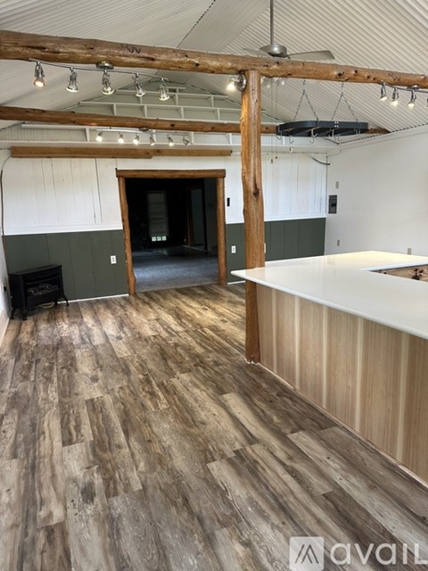 A room with a carpeted floor and a ceiling fan.