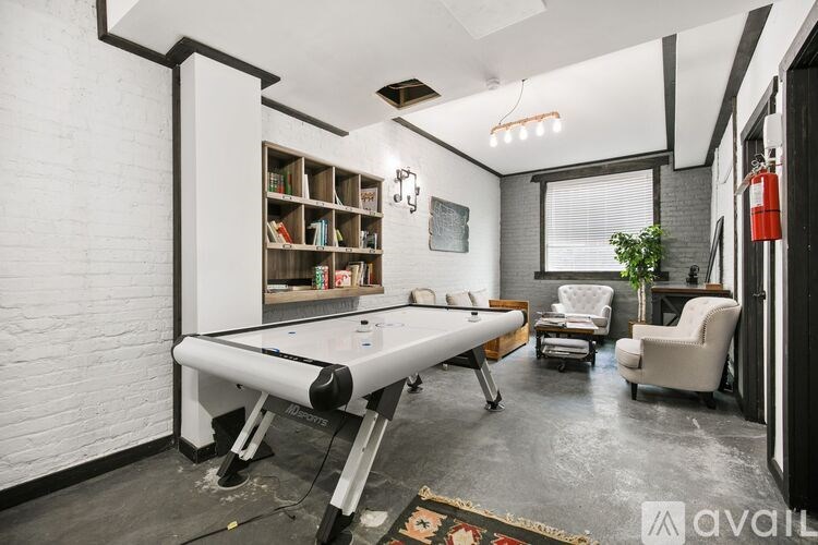 A room with a pool table and a fire extinguisher on the wall.