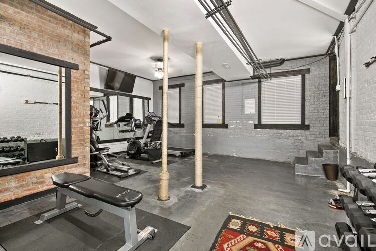A gym with a bench, weights, and exercise equipment.
