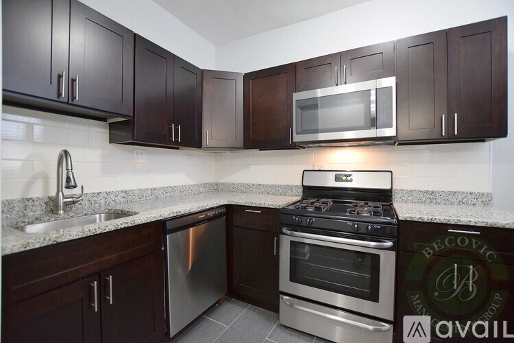 A kitchen with dark brown cabinets and a stainless steel dishwasher and oven.
